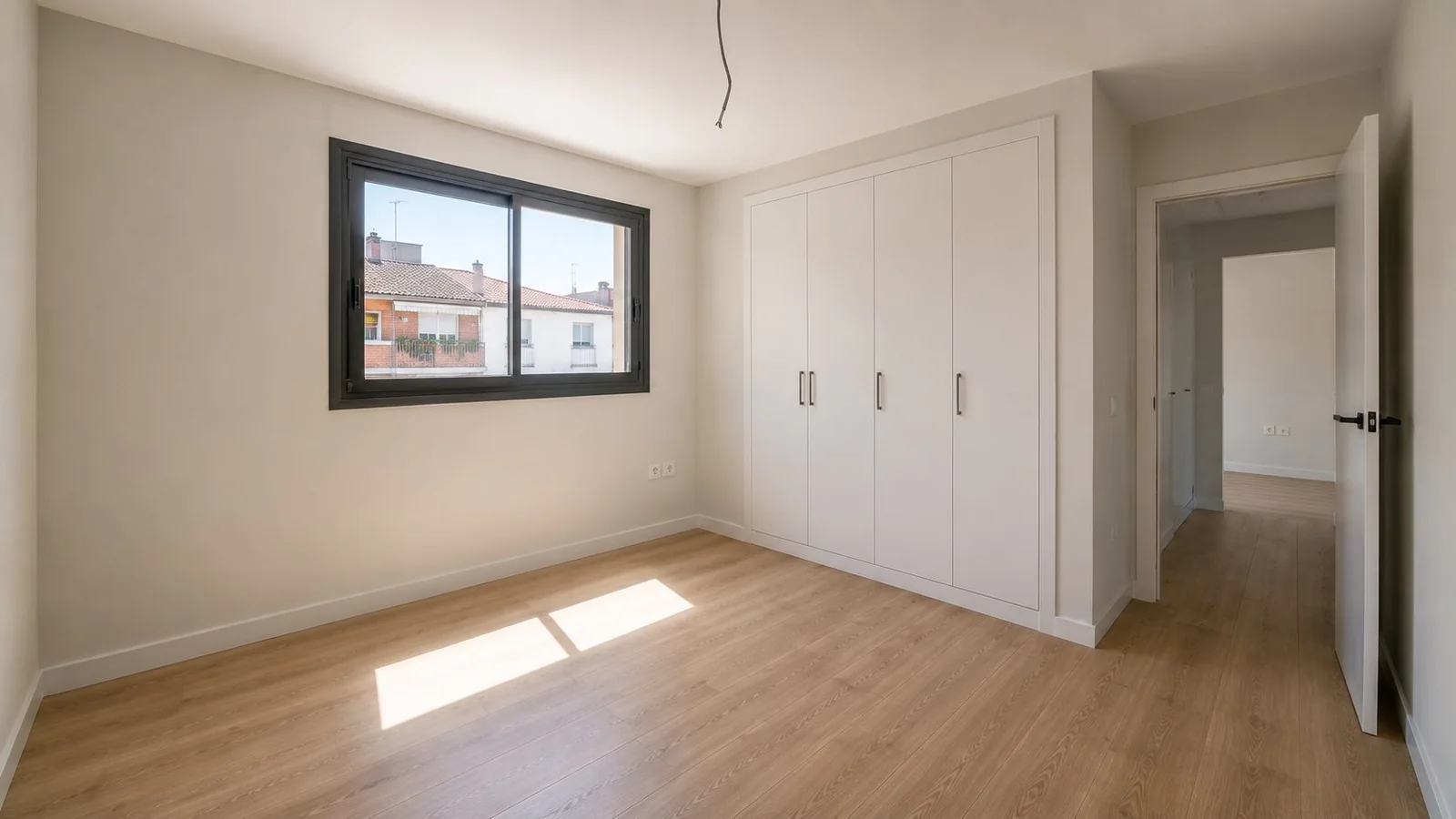Habitación reformada con armarios empotrados y suelo laminado