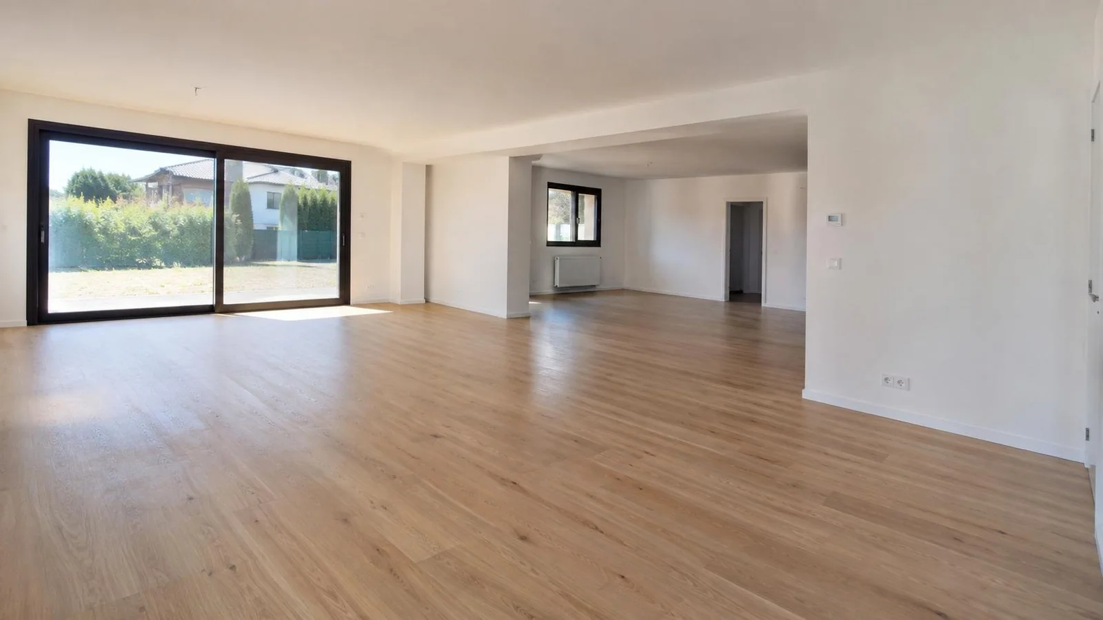 Salón reformado con suelo laminado y paredes lisas